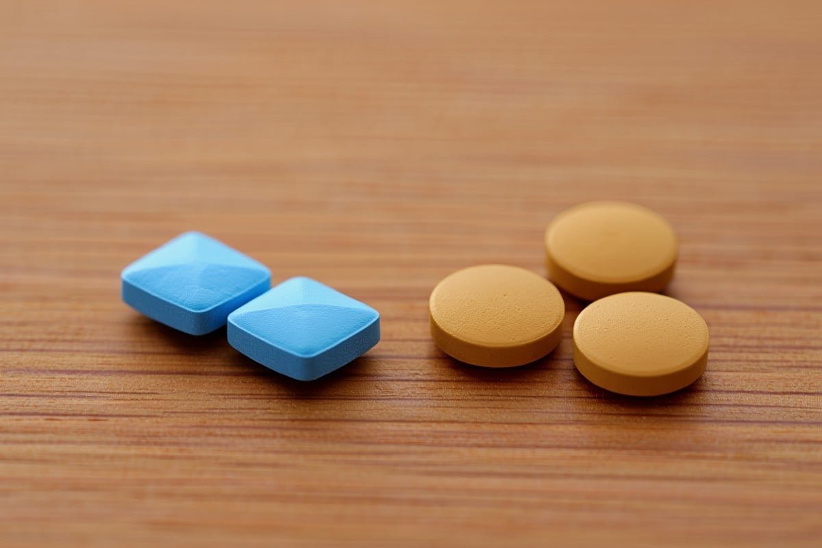 Una foto de pastillas azules de sildenafilo y marrones de vardenafilo en el mostrador de una farmacia.